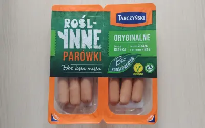 Opakowanie roślinnych parówek Tarczyński z widocznymi parówkami w środku.