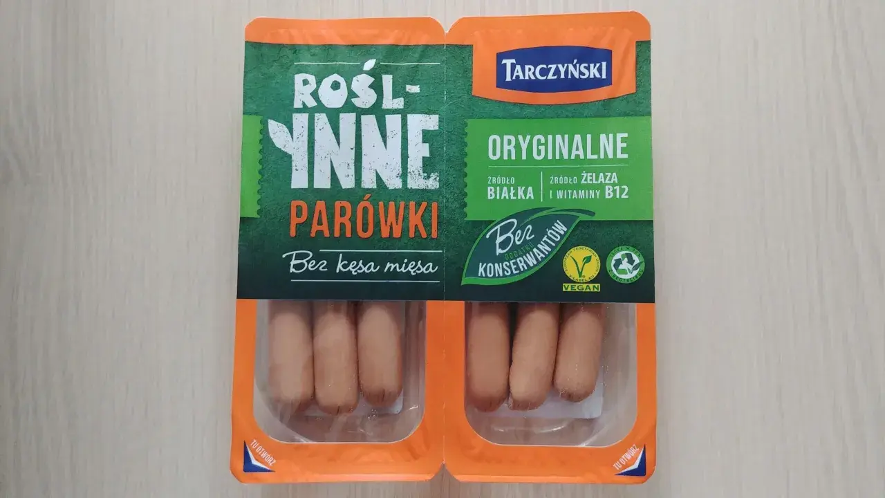 Opakowanie roślinnych parówek Tarczyński z widocznymi parówkami w środku.