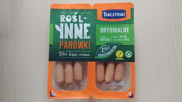 Opakowanie roślinnych parówek Tarczyński z widocznymi parówkami w środku.